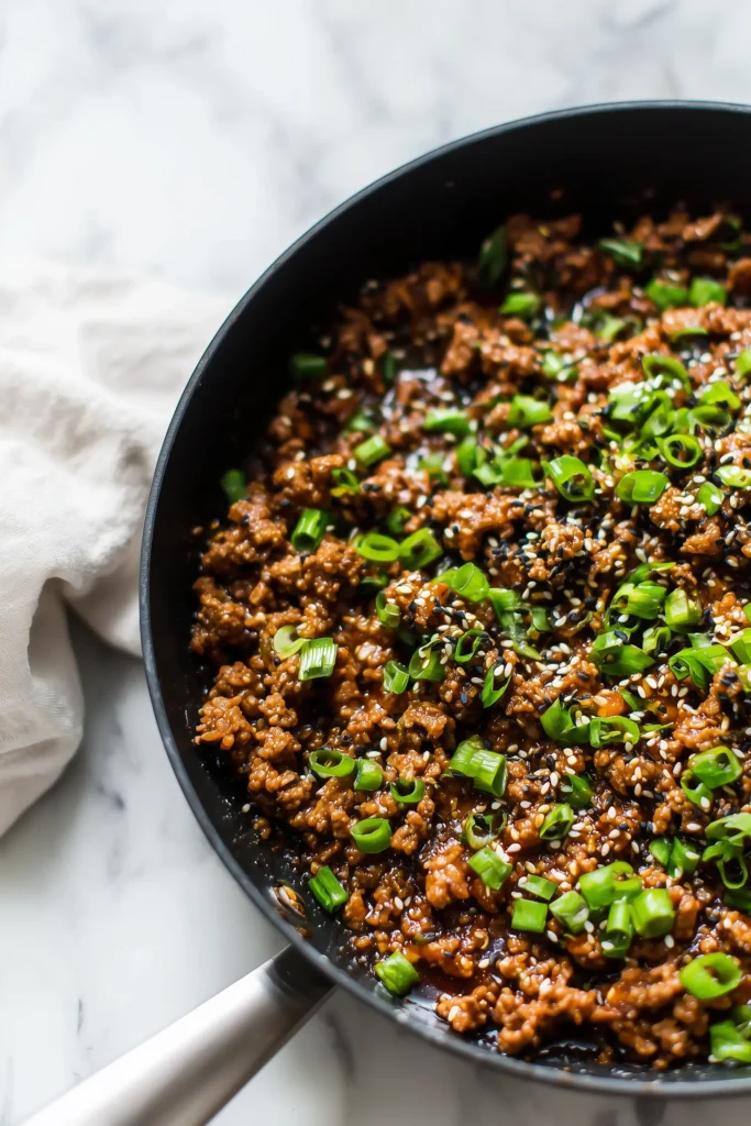 Korean Ground Beef Bowl 3 Skillet of caramelized Korean-style ground beef with green onions and sesame seeds.