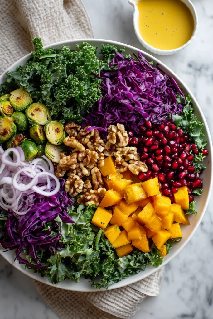 Winter Christmas Salad With Honey Mustard Dressing 2 Overhead view of ingredients for Winter Christmas Salad With Honey Mustard Dressing, arranged on a board and marble surface.