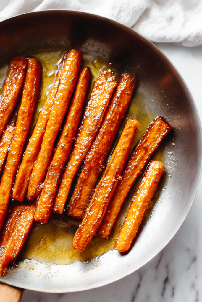 Caramelized Carrots with Feta, Walnuts & Cranberry-Honey Glaze 2 Caramelized Carrots with Feta, Walnuts & Cranberry-Honey Glaze glistening in a skillet with golden, buttery edges.