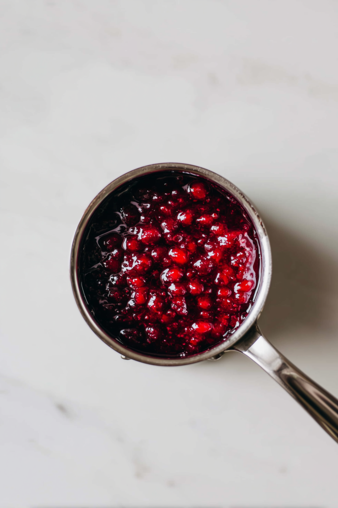 Caramelized Carrots with Feta, Walnuts & Cranberry-Honey Glaze 3 A saucepan of cranberry-honey glaze for Caramelized Carrots with Feta, Walnuts & Cranberry-Honey Glaze, bubbling and glossy.