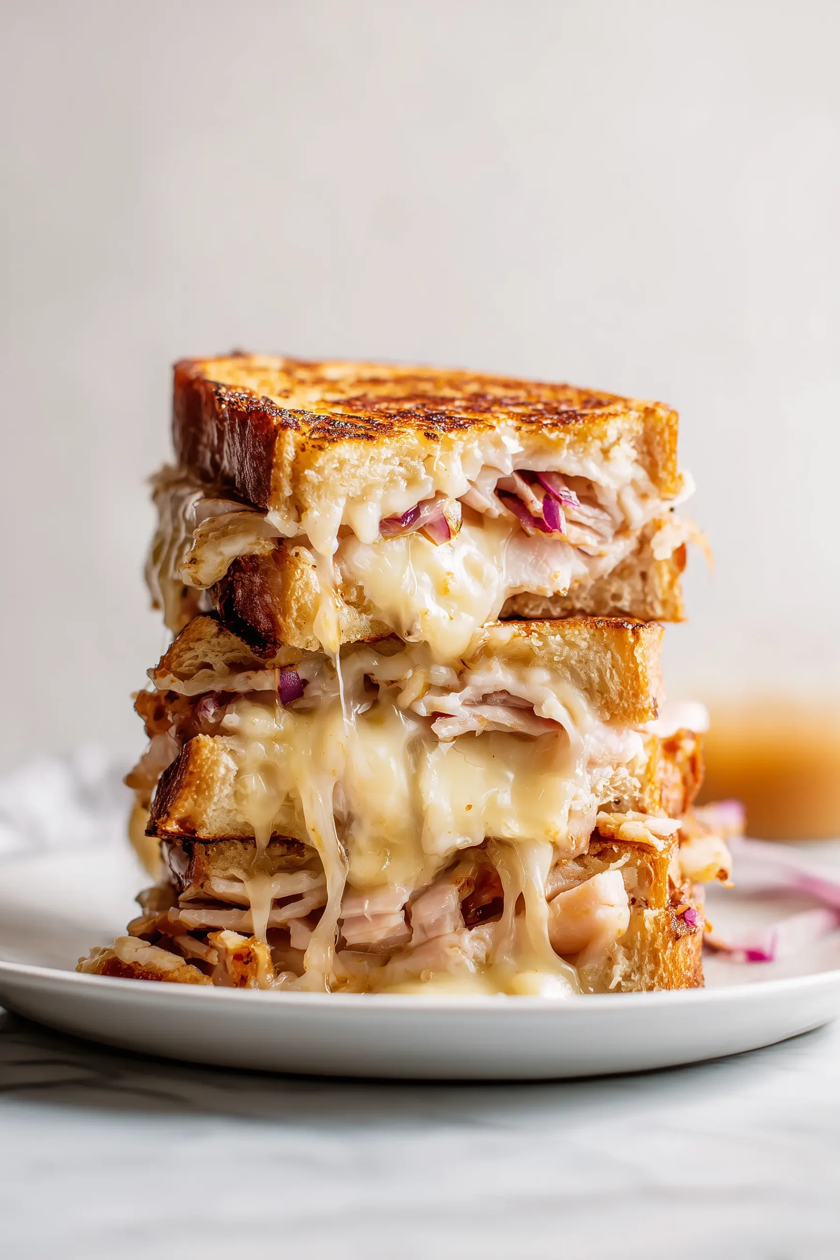 Golden Turkey Dijon Melt Sandwiches layered with turkey, melted cheese, and Dijon on crisp bread.