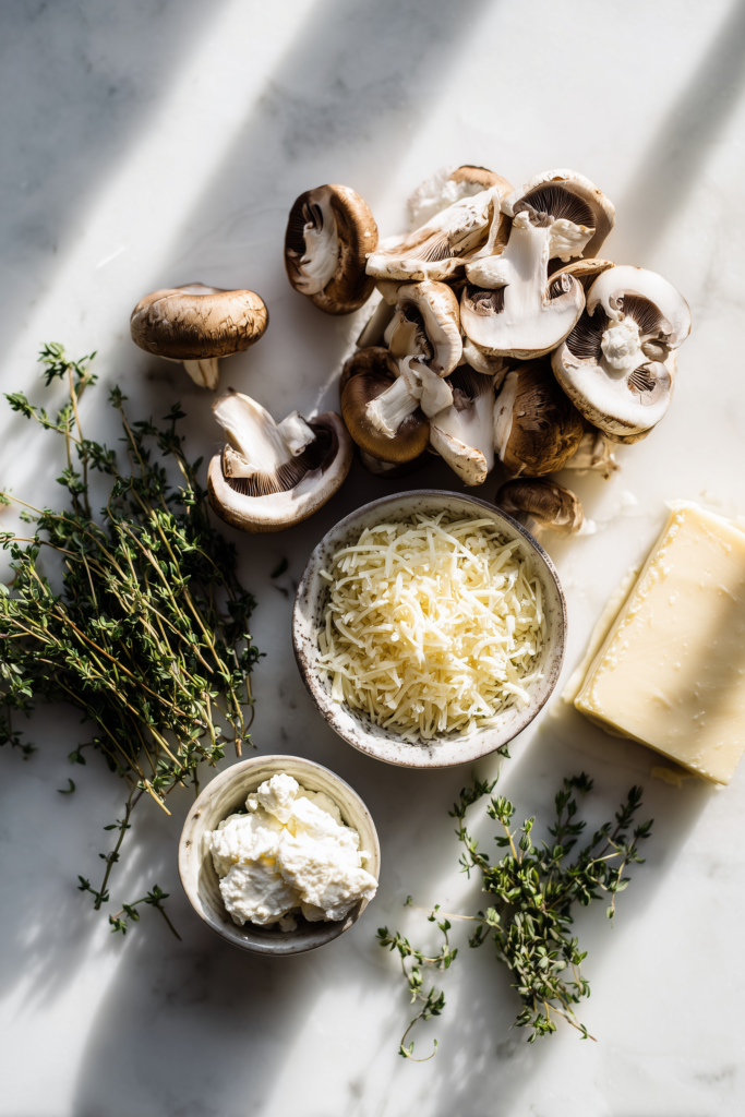 Ingredients for Savory Mushroom & Gruyère Puff Pastry Braid Recipe arranged on a bright marble background.