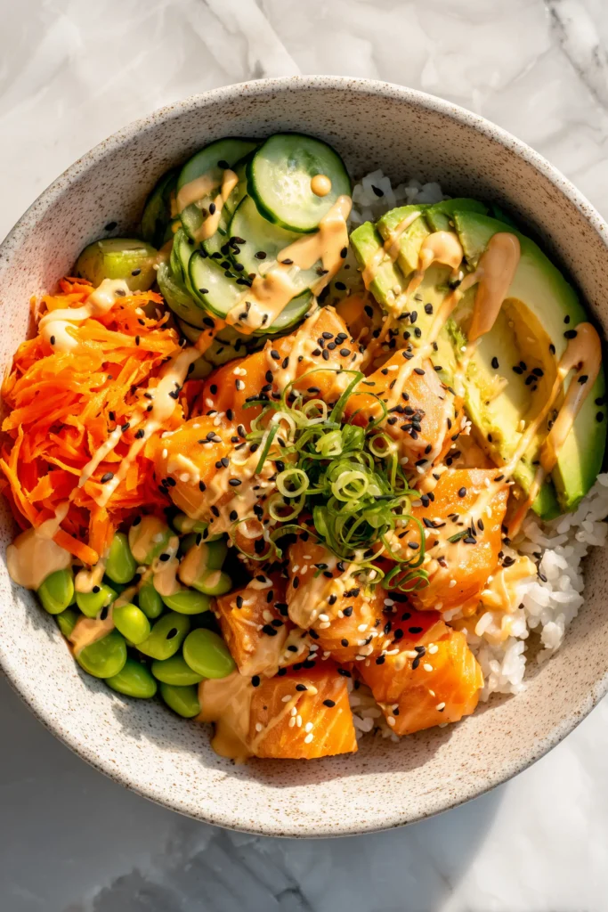 Spicy Salmon Rice Bowl 4 Overhead view of Spicy Salmon Rice Bowl with golden salmon, colorful vegetables, and creamy spicy sauce.