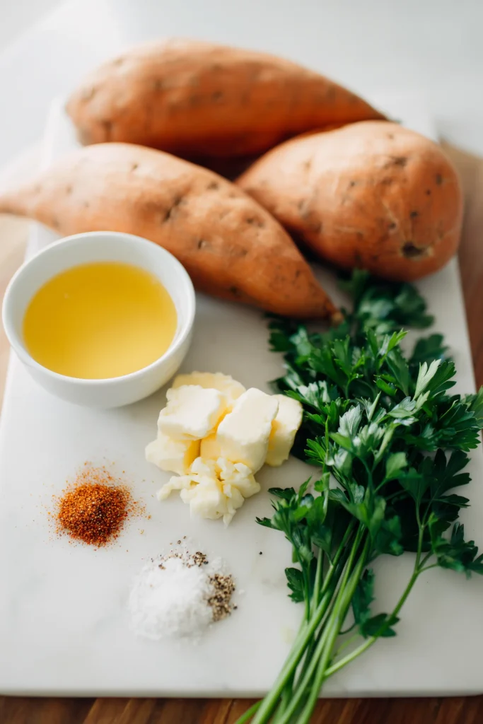 Savory Garlic Butter Roasted Sweet Potatoes ingredients neatly laid out on a white marble board.