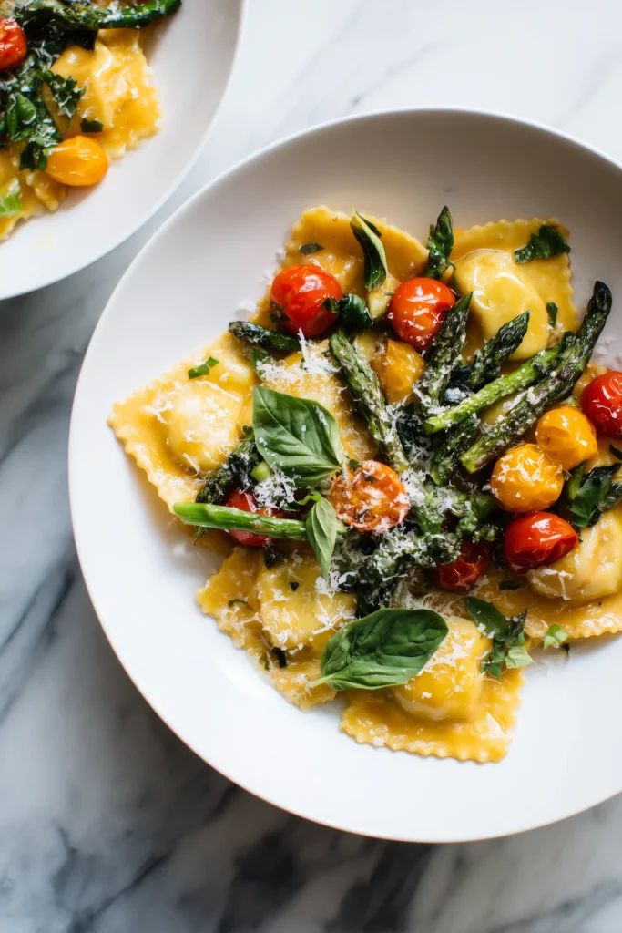 Plate of Ravioli with Tomatoes and Asparagus with basil and parmesan on a marble background.