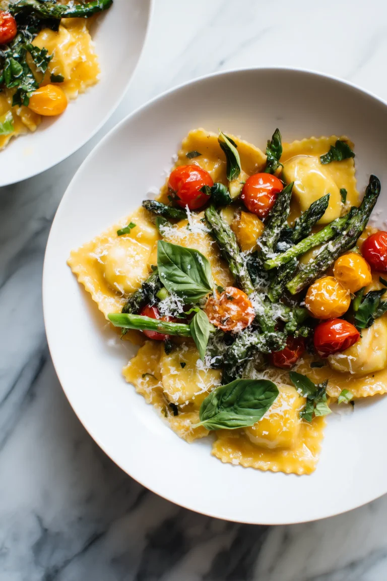 Plate of Ravioli with Tomatoes and Asparagus with basil and parmesan on a marble background.